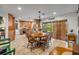 Open-concept dining area with wood floors, a chandelier, and views of the kitchen and backyard at 200 W Washington Ave, Deland, FL 32720