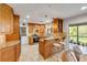 A kitchen with wooden cabinets, granite countertops, an island with stools, and an open doorway to the backyard at 200 W Washington Ave, Deland, FL 32720