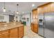 Open kitchen with stainless steel refrigerator, granite counters, and wooden cabinets at 200 W Washington Ave, Deland, FL 32720