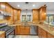 Kitchen showcasing wood cabinets, stainless steel appliances, granite counters, and a view to the backyard at 200 W Washington Ave, Deland, FL 32720
