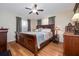 Comfortable main bedroom featuring a ceiling fan, wood floors, and elegant decor at 210 Delespine Dr, Debary, FL 32713