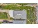 A high-angle aerial shot shows the architectural details of the roof, patio, driveway, and surrounding greenery at 2101 Hill St, New Smyrna Beach, FL 32169