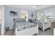 Charming bedroom featuring two beds, cool blue walls, and beachy decor for a relaxing coastal retreat at 2101 Hill St, New Smyrna Beach, FL 32169