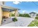 A covered carport with seating area provides convenient parking and shelter, surrounded by tropical landscaping and paved drive at 2101 Hill St, New Smyrna Beach, FL 32169