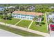 Aerial view of a row of townhouses featuring a well-manicured lawn and vibrant turquoise shutters at 2122 S Atlantic Ave # 2122, New Smyrna Beach, FL 32169