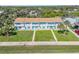 Aerial view of townhouses with well-kept lawns, turquoise shutters, and lush surrounding greenery at 2122 S Atlantic Ave # 2122, New Smyrna Beach, FL 32169