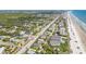 Sweeping aerial view of the property with beach access, surrounded by lush greenery and neighborhood charm at 2122 S Atlantic Ave # 2122, New Smyrna Beach, FL 32169
