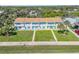 Aerial view highlighting one of a row of townhouses featuring a well-manicured lawn and vibrant turquoise shutters at 2122 S Atlantic Ave # 2122, New Smyrna Beach, FL 32169