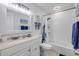 All-white bathroom with a tub-shower combo, framed mirror, and coastal-themed decorations for a fresh, clean feel at 2122 S Atlantic Ave # 2122, New Smyrna Beach, FL 32169