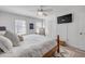 Bright bedroom with modern ceiling fan, minimalist decor, and white shuttered windows at 2122 S Atlantic Ave # 2122, New Smyrna Beach, FL 32169