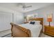 Bright bedroom featuring a wooden sleigh bed with white linens, a ceiling fan, and ample closet space at 2122 S Atlantic Ave # 2122, New Smyrna Beach, FL 32169