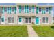 Inviting townhome featuring a tidy lawn, charming blue shutters, and a well-maintained facade at 2122 S Atlantic Ave # 2122, New Smyrna Beach, FL 32169