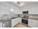 Well-lit kitchen showcasing stainless steel appliances, granite countertops, and white cabinetry at 2122 S Atlantic Ave # 2122, New Smyrna Beach, FL 32169