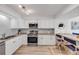 Well-lit kitchen featuring granite countertops, stainless appliances, white cabinets, and barstool seating at 2122 S Atlantic Ave # 2122, New Smyrna Beach, FL 32169