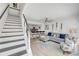 Bright living room with a comfortable gray couch, guitars hanging on the wall, and stairway at 2122 S Atlantic Ave # 2122, New Smyrna Beach, FL 32169
