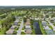 Aerial view of a well-maintained neighborhood alongside a beautiful golf course with ponds and lush greenery at 223 Ne Golf Club Dr, New Smyrna Beach, FL 32168