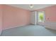 Inviting bedroom with cozy carpeting, closet space, and a window offering serene views of the outdoors at 223 Ne Golf Club Dr, New Smyrna Beach, FL 32168