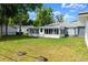 The home has a spacious backyard with tree stumps and a screened-in porch at 2325 Lime Tree Dr, Edgewater, FL 32141