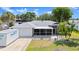 Charming single-story home with a gray exterior, two-car garage, a screened in porch, and manicured lawn at 2325 Lime Tree Dr, Edgewater, FL 32141