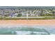 Aerial image showcasing the coastline, the beach, ocean waves, and the homes in the adjacent neighborhood at 25 Dolphin Ave, Ormond Beach, FL 32176