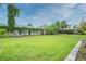 Wide shot of a grassy backyard with a wooden fence, trees, and green ground cover at 25 Dolphin Ave, Ormond Beach, FL 32176