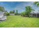 Large, green backyard with mature trees, a wooden fence, and healthy green grass at 25 Dolphin Ave, Ormond Beach, FL 32176