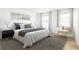 Bright bedroom with two windows, modern side tables, a plush rug, and a comfortable queen bed at 25 Dolphin Ave, Ormond Beach, FL 32176