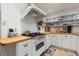 Bright kitchen with butcher block countertops, white cabinets, open shelving, and modern appliances for efficient cooking at 25 Dolphin Ave, Ormond Beach, FL 32176