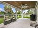 Relaxing porch area with a ceiling fan, comfortable seating, and a view of the green backyard at 2529 Umbrella Tree Dr, Edgewater, FL 32141