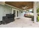 Spacious covered patio with ceiling fan, outdoor furniture, and gas grill at 2529 Umbrella Tree Dr, Edgewater, FL 32141