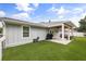 Beautiful house exterior with lush green lawn, an outdoor seating area, and a grill for entertainment at 2529 Umbrella Tree Dr, Edgewater, FL 32141