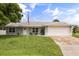 Charming single-story home with well-manicured lawn, neutral paint, and an attached two car garage at 2529 Umbrella Tree Dr, Edgewater, FL 32141