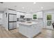 Bright kitchen featuring white cabinets, stainless steel appliances, and an island with seating at 2529 Umbrella Tree Dr, Edgewater, FL 32141
