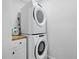 Practical laundry area with stacked washer and dryer units, and a countertop for folding and organizing laundry at 2529 Umbrella Tree Dr, Edgewater, FL 32141