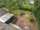 An aerial view of a private backyard with landscaped beds, a screen lanai, and mature trees at 2628 Vista Palm Dr, Edgewater, FL 32141