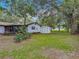 Spacious backyard featuring a well-maintained lawn, shed, mature trees, and access to the screened-in lanai at 2628 Vista Palm Dr, Edgewater, FL 32141