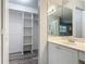 Bathroom with vanity, mirrored wall, and closet with built-in shelving at 2628 Vista Palm Dr, Edgewater, FL 32141