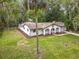 Aerial view of home with a manicured lawn, lush trees, circular driveway, and Mediterranean-style facade at 2628 Vista Palm Dr, Edgewater, FL 32141