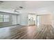 Open living space with wood-look floors, ceiling fan, and view into kitchen at 2628 Vista Palm Dr, Edgewater, FL 32141