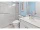 Bright bathroom features a glass-enclosed shower, white vanity, and a decorative mirror at 2632 Turnbull Estates Dr, New Smyrna Beach, FL 32168