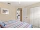 Neutral bedroom boasts a coastal vibe with a striped bedspread and access to other living areas at 2632 Turnbull Estates Dr, New Smyrna Beach, FL 32168