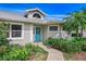 Inviting front entrance with blue door, lush landscaping, and a well-lit entryway at 2632 Turnbull Estates Dr, New Smyrna Beach, FL 32168