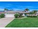 Charming single-story home with lush landscaping, blue door, and a two car garage at 2632 Turnbull Estates Dr, New Smyrna Beach, FL 32168