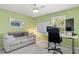 Green home office with a comfortable couch, work space, and bright natural light at 2632 Turnbull Estates Dr, New Smyrna Beach, FL 32168