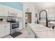 Well-lit kitchen showcasing stainless steel appliances, white cabinets, and tiled backsplash at 2632 Turnbull Estates Dr, New Smyrna Beach, FL 32168
