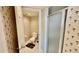 Cozy bathroom features a walk-in shower and patterned wallpaper at 2700 N Peninsula Ave # 322, New Smyrna Beach, FL 32169