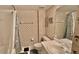 Bathroom featuring white tiling, palm tree wallpaper, and tub with blue seashell shower curtain at 2700 N Peninsula Ave # 322, New Smyrna Beach, FL 32169
