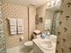 Bathroom featuring white tiling, palm tree wallpaper, and decorative seashell accents at 2700 N Peninsula Ave # 322, New Smyrna Beach, FL 32169