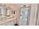 Bathroom with double vanity and mirror, plus patterned wallpaper and an open doorway to the bedroom at 2700 N Peninsula Ave # 322, New Smyrna Beach, FL 32169