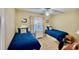 Bedroom features two beds, a ceiling fan, neutral walls, and natural light at 2700 N Peninsula Ave # 322, New Smyrna Beach, FL 32169